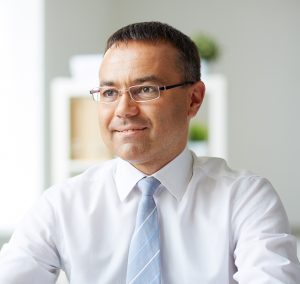 Portrait of mature businessman looking at his secretary while speaking to her